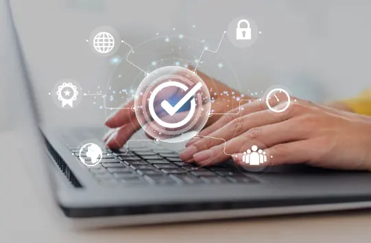 Pessoa digitando em notebook com ícones de proteção e conformidade com LGPD